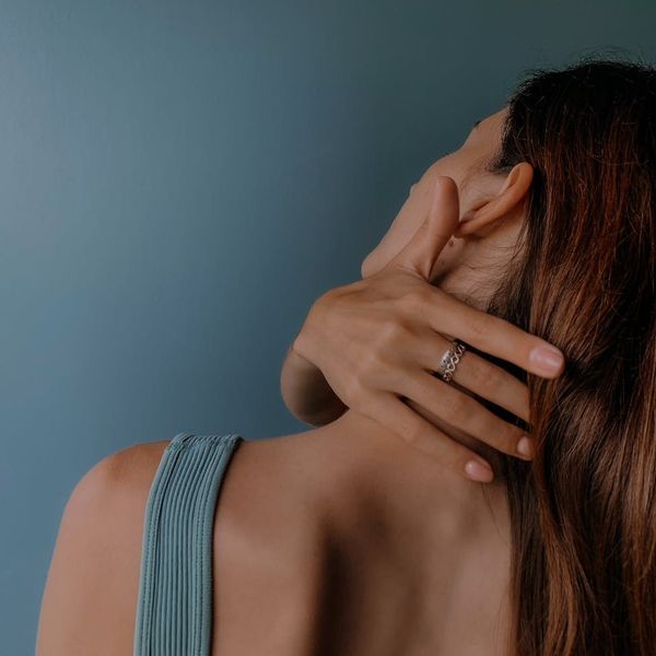 Person practicing a gentle neck stretch in a calm, well-lit room.