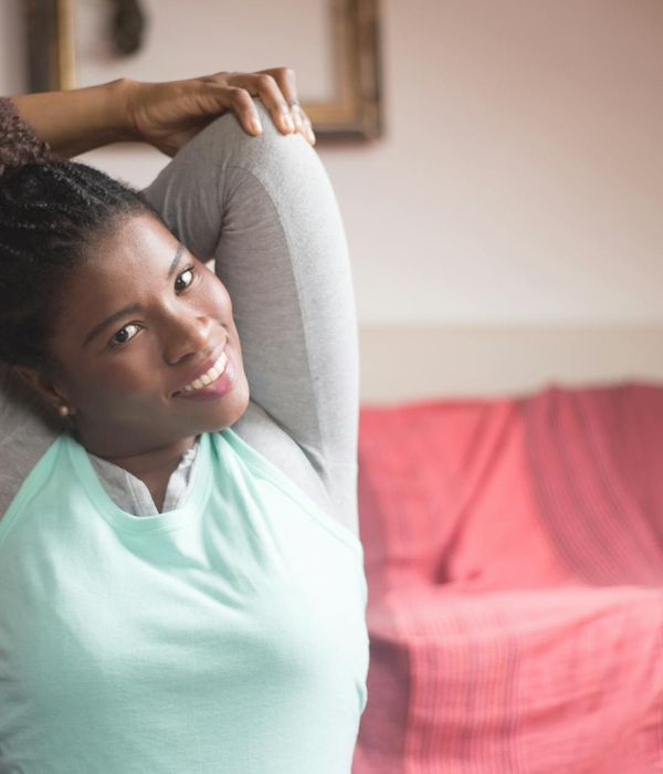 Smiling person stretching arms upward, feeling refreshed and energized.